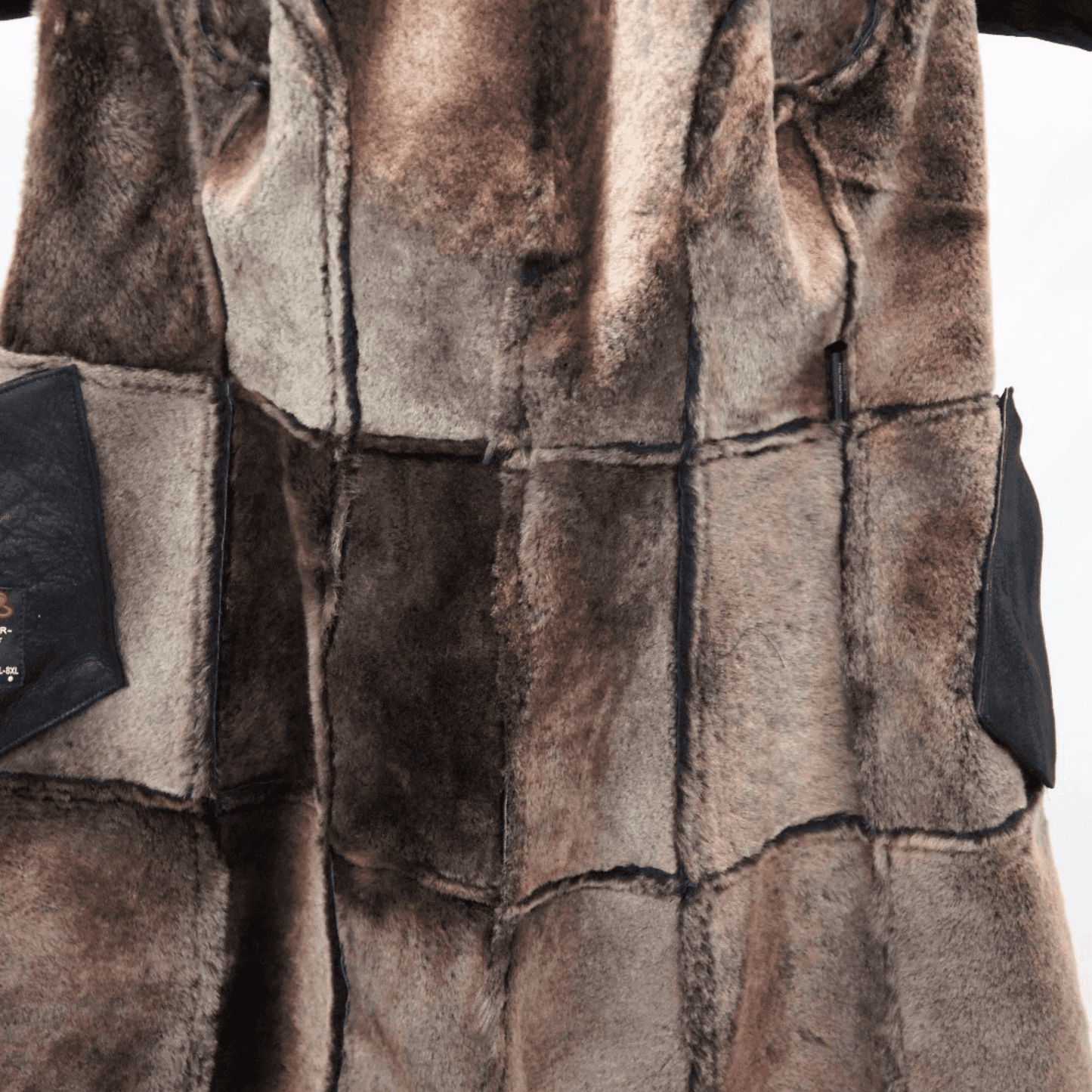 Close up of brown patchwork Sheepskin Shearling Coat interior showing soft fur panels and leather trim pockets