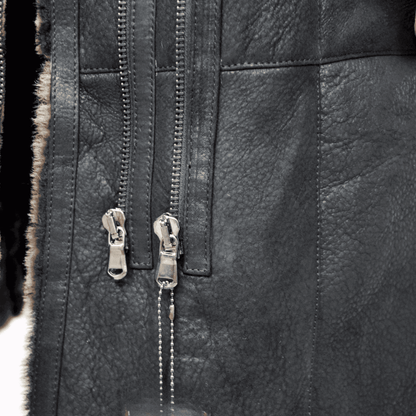 Black Sheepskin Shearling Coat close up showing textured leather exterior dual metal zippers and fur trim
